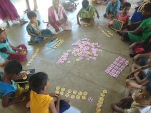 Young children sitting in a circle doing puzzles and games